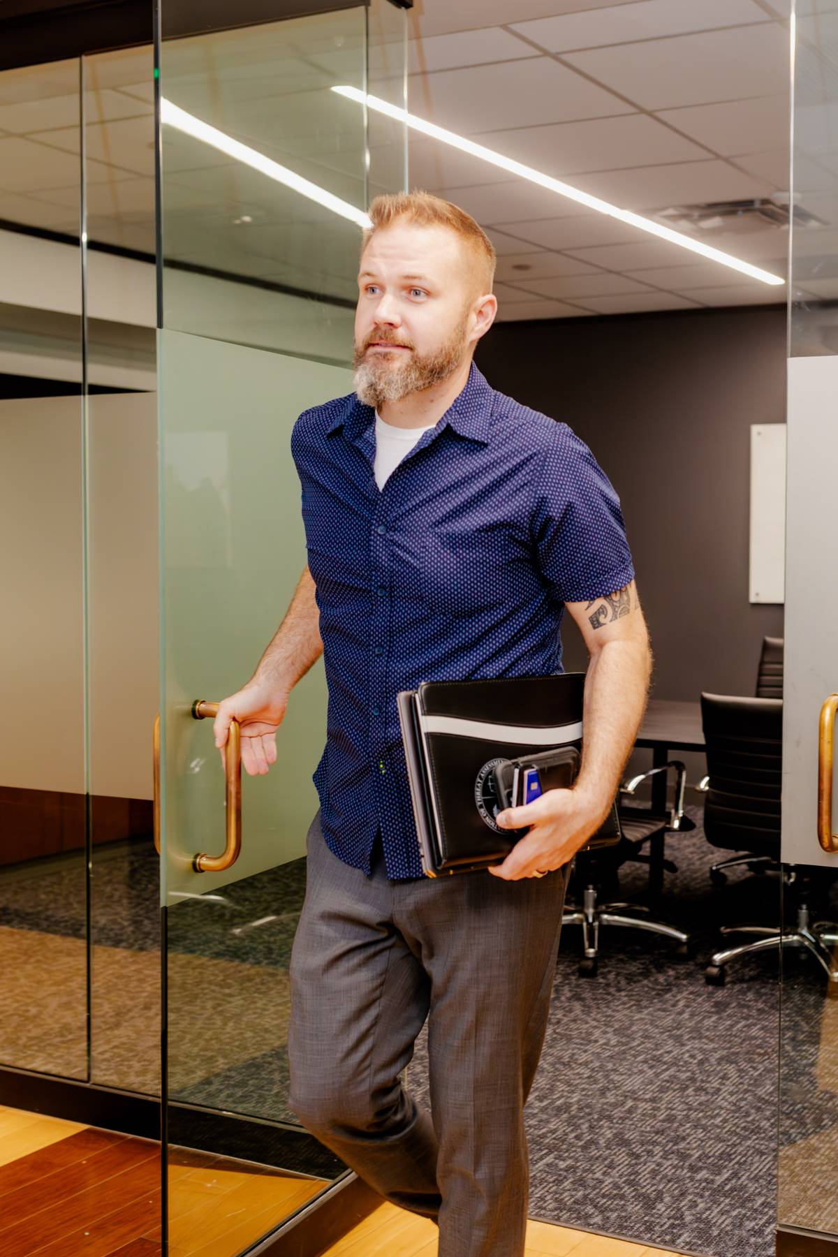 Matt Nelson stepping into a San Antonio conference room with client briefs in hand